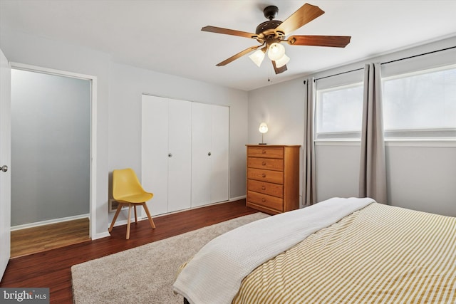 bedroom with a closet, ceiling fan, baseboards, and wood finished floors