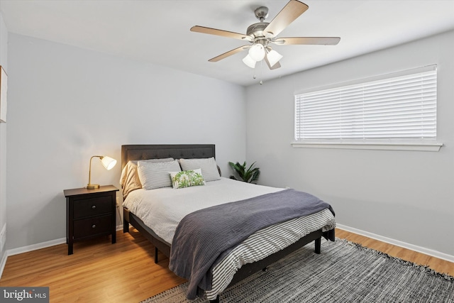 bedroom featuring a ceiling fan, light wood-type flooring, and baseboards