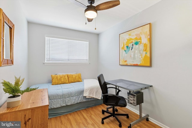 bedroom featuring ceiling fan, wood finished floors, and baseboards