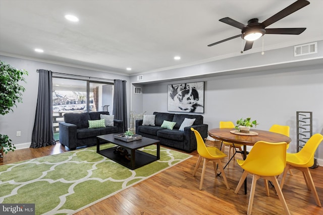 living room featuring ornamental molding, recessed lighting, visible vents, and wood finished floors