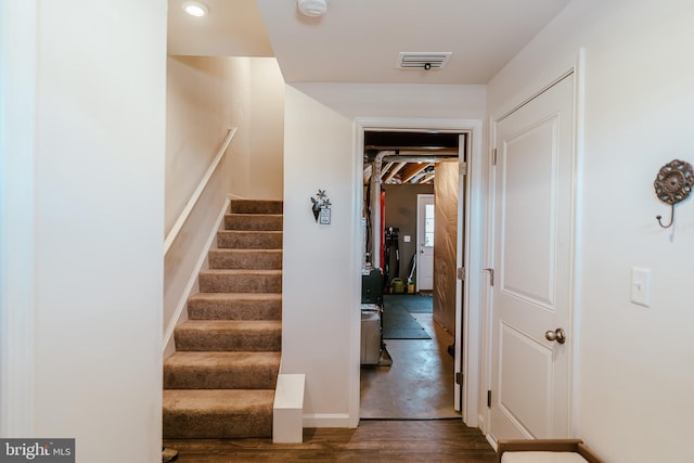 stairway featuring visible vents and wood finished floors