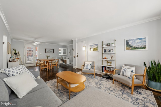 living area with ornamental molding, a ceiling fan, baseboards, and wood finished floors