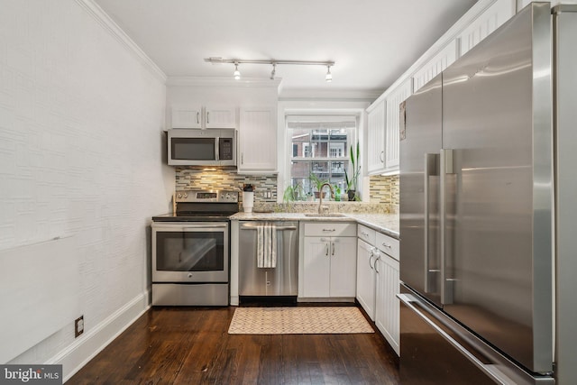 kitchen with a sink, dark wood-type flooring, appliances with stainless steel finishes, and white cabinetry