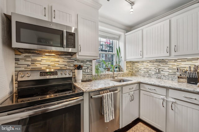 kitchen featuring a sink, stainless steel appliances, backsplash, and white cabinetry