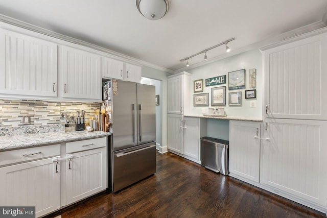 kitchen featuring dark wood-type flooring, white cabinetry, freestanding refrigerator, decorative backsplash, and light stone countertops