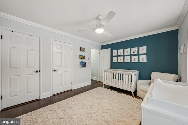 bedroom with a ceiling fan, baseboards, dark wood finished floors, ornamental molding, and a nursery area