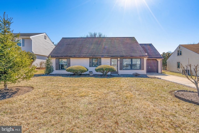 view of front of home featuring concrete driveway, a front lawn, and an attached garage