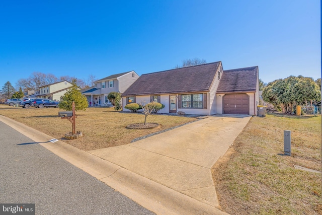 view of front of house with a garage, a front yard, concrete driveway, and a shingled roof