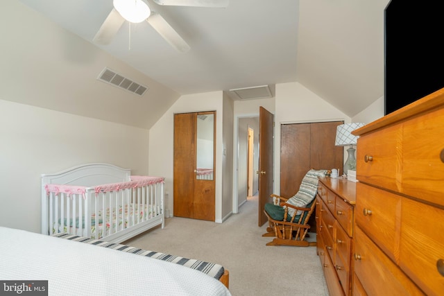 bedroom with lofted ceiling, light carpet, visible vents, and a ceiling fan