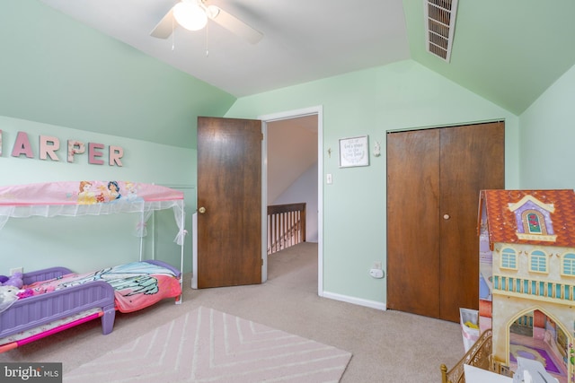 carpeted bedroom featuring lofted ceiling, ceiling fan, visible vents, baseboards, and a closet