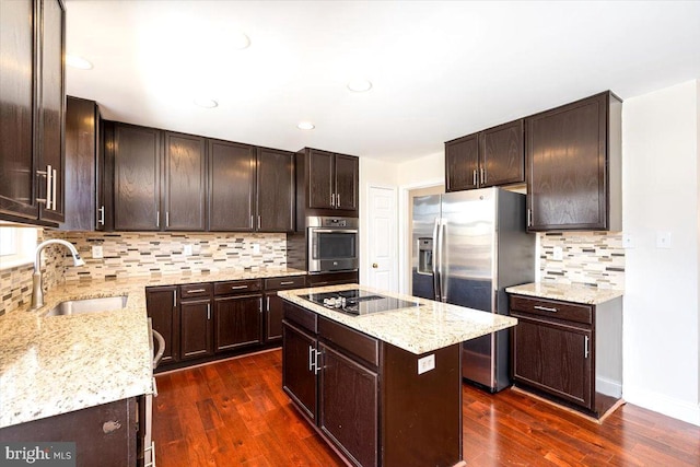 kitchen with dark wood-type flooring, black electric stovetop, stainless steel refrigerator with ice dispenser, and a sink