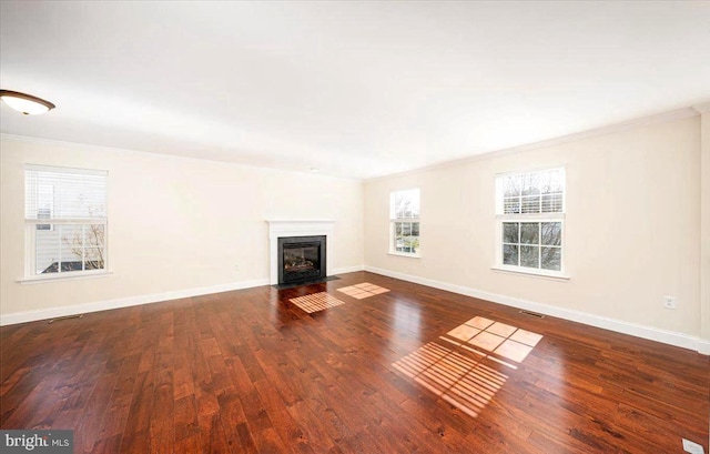 unfurnished living room with ornamental molding, visible vents, baseboards, and wood finished floors