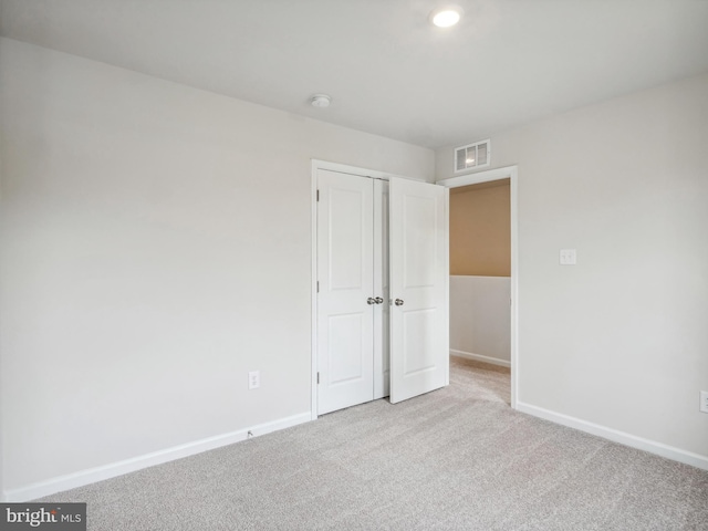 unfurnished bedroom featuring a closet, carpet, visible vents, and baseboards