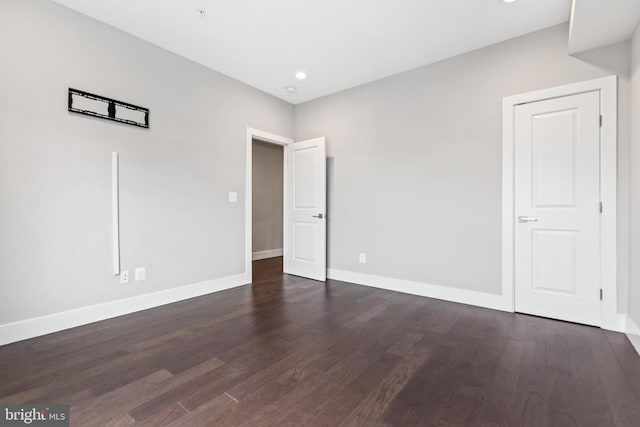 unfurnished bedroom featuring dark wood-style floors, baseboards, and recessed lighting