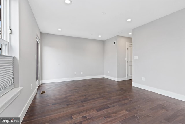 unfurnished living room with dark wood-style floors, recessed lighting, visible vents, and baseboards