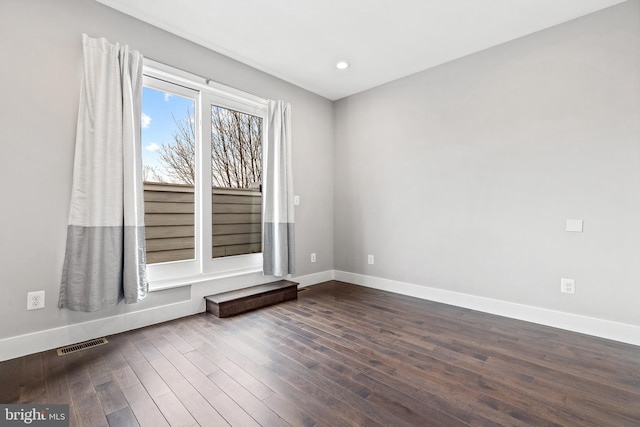 unfurnished room with dark wood-style floors, baseboards, visible vents, and recessed lighting