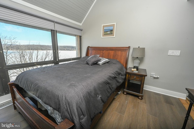 bedroom featuring wood finished floors, visible vents, baseboards, vaulted ceiling, and ornamental molding