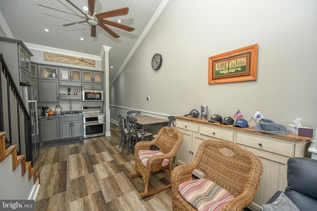 interior space with stainless steel appliances, dark wood-style flooring, ornamental molding, gray cabinets, and glass insert cabinets