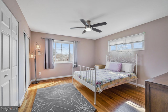 bedroom featuring ceiling fan, baseboards, and wood finished floors