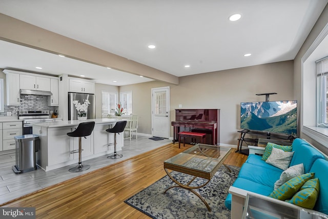 living area featuring light wood finished floors, recessed lighting, and baseboards