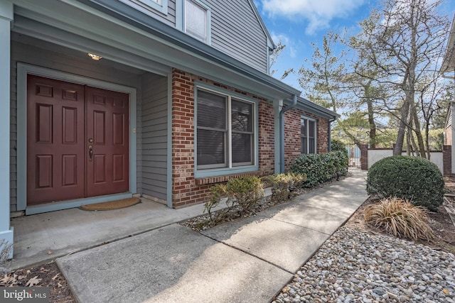 doorway to property with brick siding