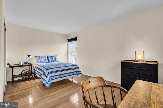 bedroom with hardwood / wood-style floors and baseboards