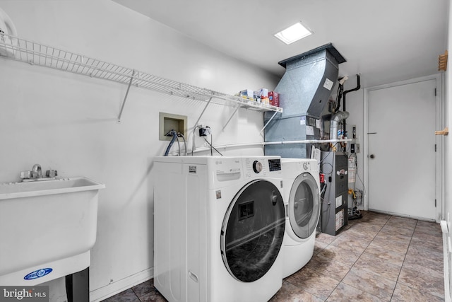 clothes washing area featuring a sink, laundry area, and washing machine and clothes dryer