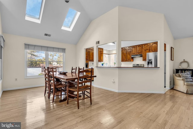 dining space featuring light wood-type flooring, baseboards, and visible vents