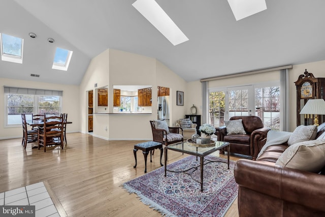 living room featuring a skylight, a wealth of natural light, and light wood-style floors