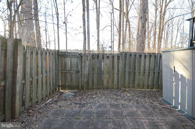 view of patio with an outbuilding, a shed, and a fenced backyard