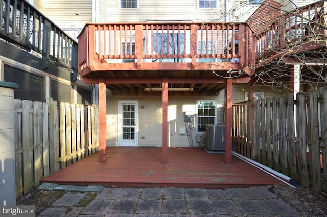 rear view of house featuring cooling unit, fence, and a wooden deck