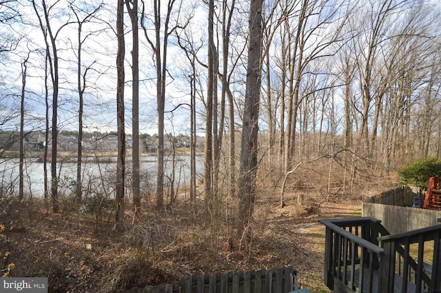 view of yard with a water view and fence