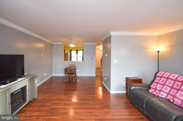 living area featuring crown molding, baseboards, and dark wood-style flooring