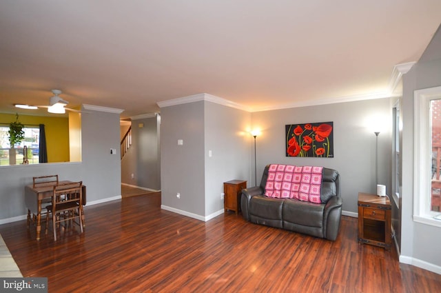 living area featuring ornamental molding, stairway, baseboards, and wood finished floors