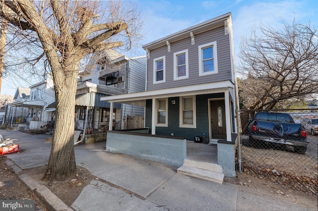 view of front of home with fence and a porch