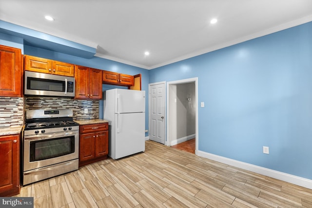 kitchen featuring wood finish floors, baseboards, appliances with stainless steel finishes, decorative backsplash, and light stone countertops