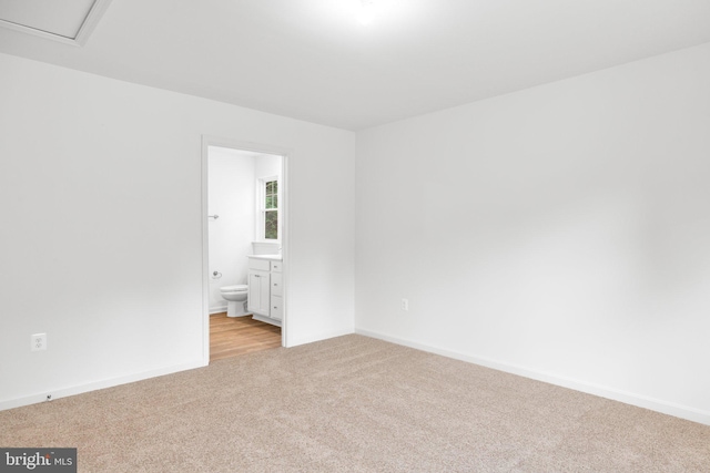 empty room featuring light colored carpet and baseboards