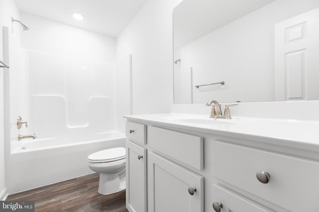 full bath with vanity, shower / washtub combination, wood finished floors, and toilet