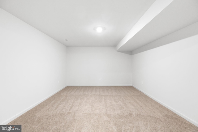 unfurnished room featuring baseboards and light colored carpet