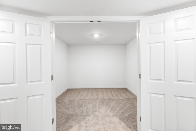 carpeted spare room featuring baseboards