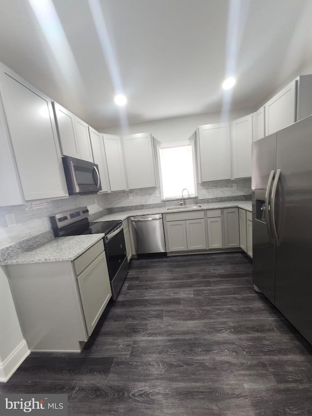 203 S Loudon Ave, Baltimore, MD 21229 - kitchen featuring appliances with stainless steel finishes, a sink, backsplash, dark wood-style floors, and white cabinets