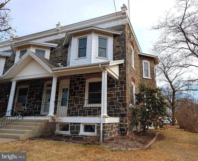 view of front of property with covered porch and stone siding