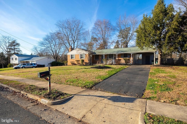 ranch-style house with fence, driveway, a chimney, a front lawn, and a carport