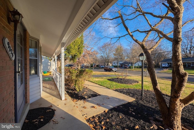 view of yard featuring covered porch and a residential view