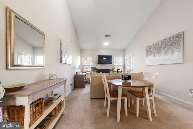 dining space featuring light carpet, a fireplace, visible vents, and a wealth of natural light