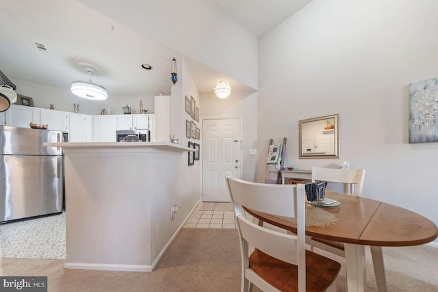 dining space featuring light tile patterned floors, baseboards, visible vents, and light colored carpet