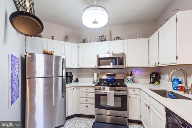 kitchen featuring white cabinetry, appliances with stainless steel finishes, light countertops, and a sink