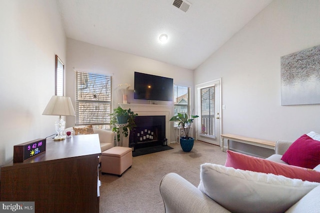 living area featuring high vaulted ceiling, carpet, visible vents, and a fireplace with flush hearth