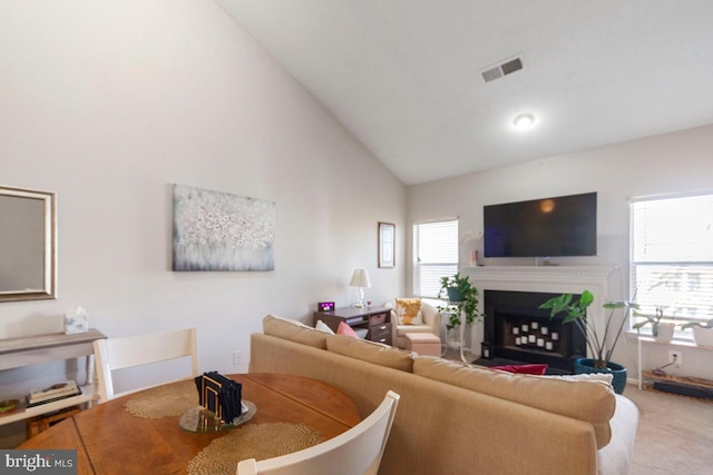 living room with carpet, plenty of natural light, a fireplace, and visible vents