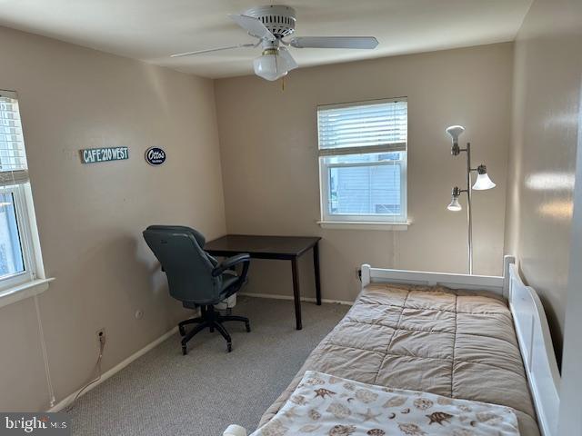 carpeted bedroom with ceiling fan and baseboards